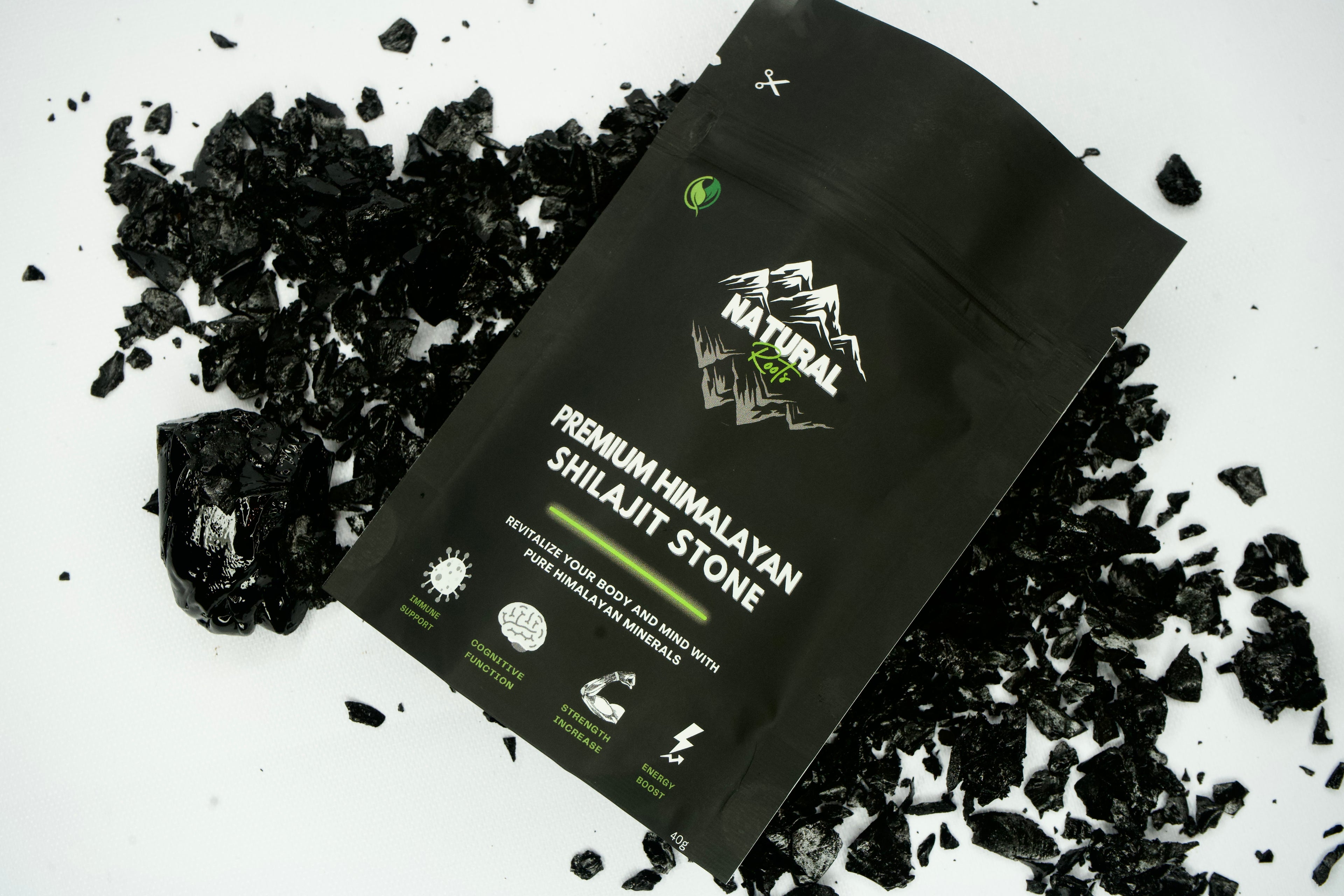 Black package of Premium Himalayan Shilajit Stone with visible branding on a white background with shilajit stones.
